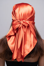 Load image into Gallery viewer, Slender black woman in a black tube top with straight brown hair below her shoulders wearing a shiny, copper colored scarf tied in a knot behind her head.
