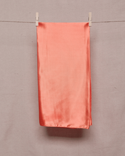 Load image into Gallery viewer, Rectangular, folded, copper colored satin scarf held on a clothesline by two clothespins in front of a light beige background
