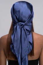 Load image into Gallery viewer, Slender black woman in a black tube top with straight brown hair below her shoulders wearing a shiny, navy blue scarf tied in a knot behind her head.
