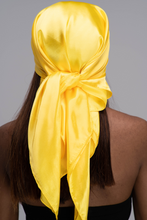 Load image into Gallery viewer, Slender black woman in a black tube top with straight brown hair below her shoulders wearing a shiny, bright yellow scarf tied in a knot behind her head.

