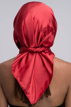 Load image into Gallery viewer, Slender black woman in a black tube top with straight brown hair below her shoulders wearing a shiny, ruby red scarf tied in a knot behind her head.
